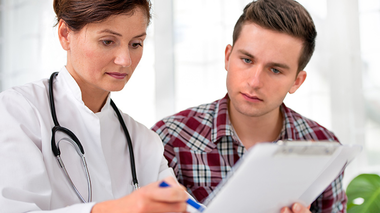 Physician and patient reviewing documents together.