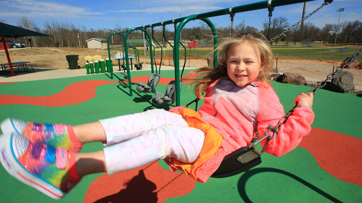Child swinging at the all-abilities Kade’s Playground in Herculaneum, Missouri.
