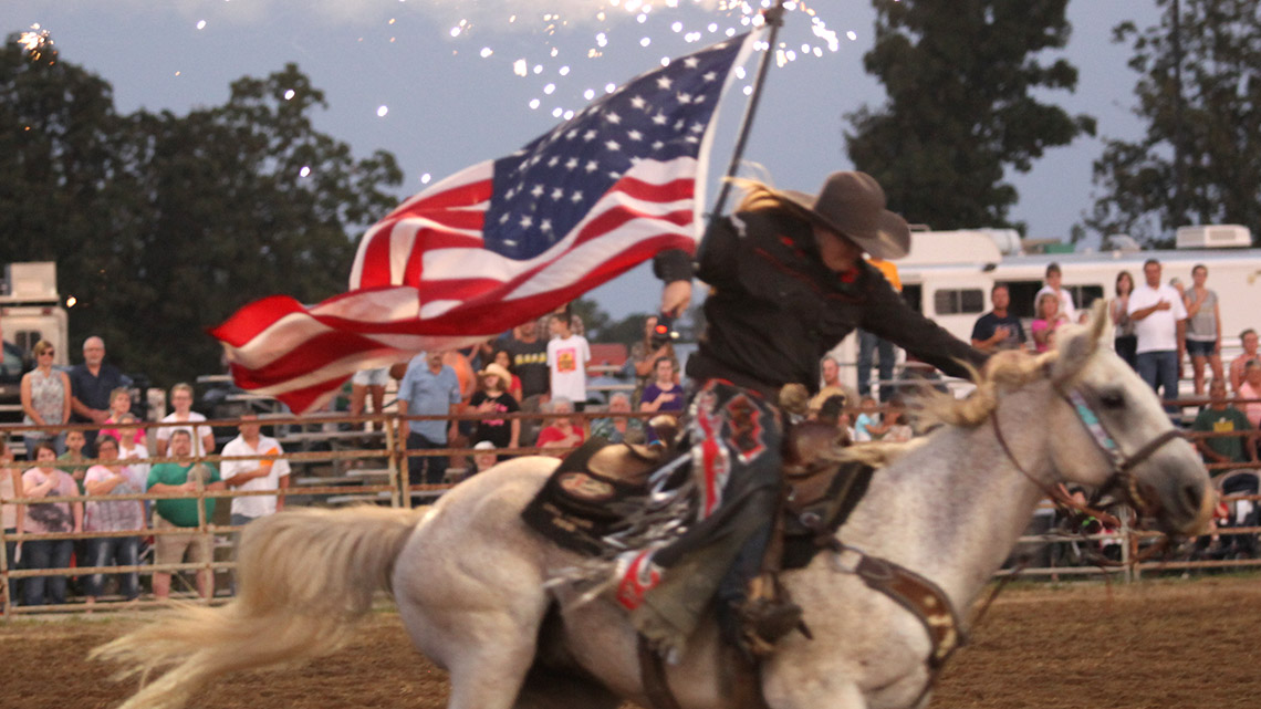 Woman on horseback carrying an American flag at the Salem, Missouri, Rodeo. Photo credit: Donald Dodd, The Salem News