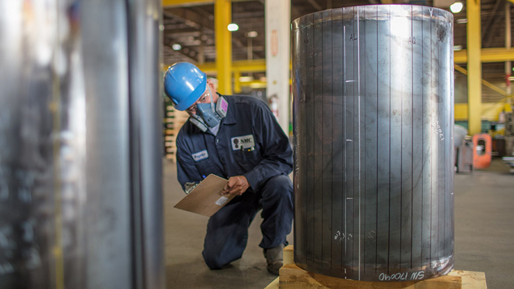 A Seafab Metals Company employee inspects a lead-lined nuclear cask.
