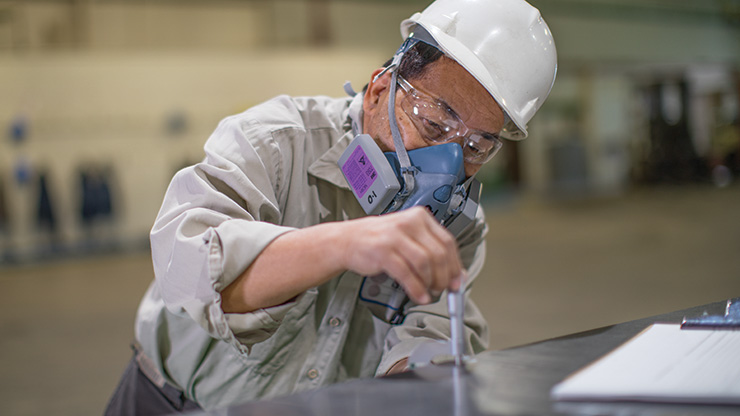 A Seafab Metals Company employee measures the thickness of a lead metal sheet to ensure it meets exacting standards.