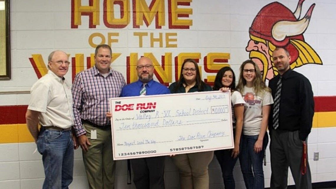 Doe Run employees present a $10,000 check to teachers and administrators of the Valley R-VI School District.